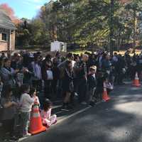 <p>Community members line up to watch the firefighters in action.</p>