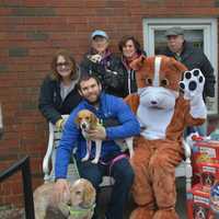 <p>Paws and Play’s owner Matt Sellechia, mascot Pawley (Andy MacMillan) and members of the Paws and Play organization with treats, toys and food it donated to Pet Rescue.</p>