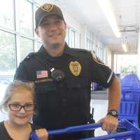 <p>Keira Decker, 8, with Officer George Featherstone.</p>