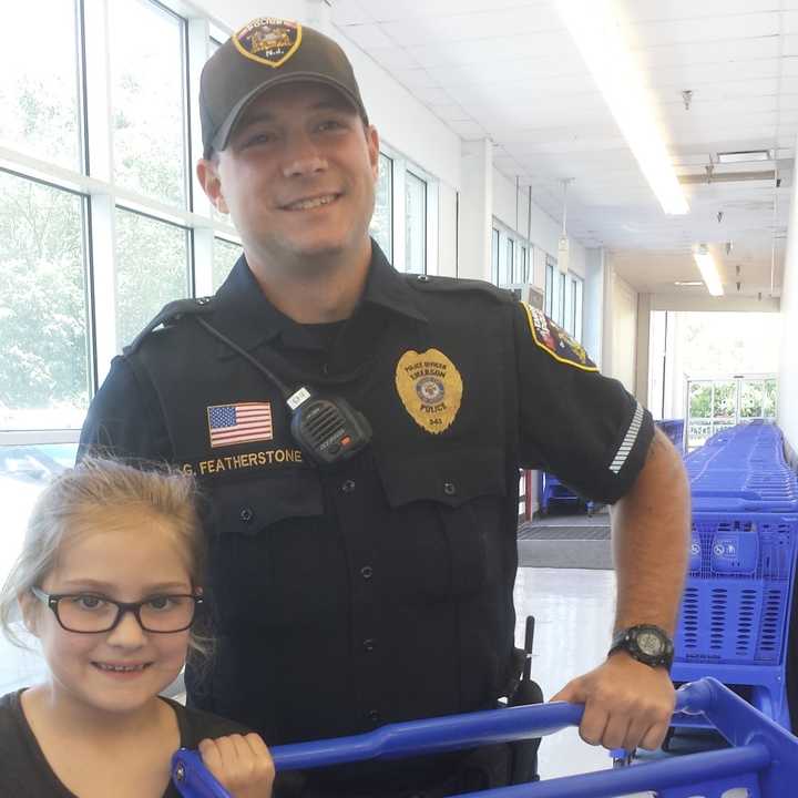 Keira Decker, 8, with Officer George Featherstone.