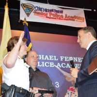 <p>Mayor Paul Aronsohn swearing in Ridgewood Police Chief Jacqueline Luthcke while her husband, Wayne, holds the Bible</p>