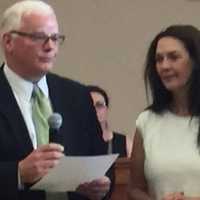 <p>Ridgewood Attorney Matt Rogers, left, swears in Ridgewood Mayor Susan Knudsen as her husband, John, looks on.</p>