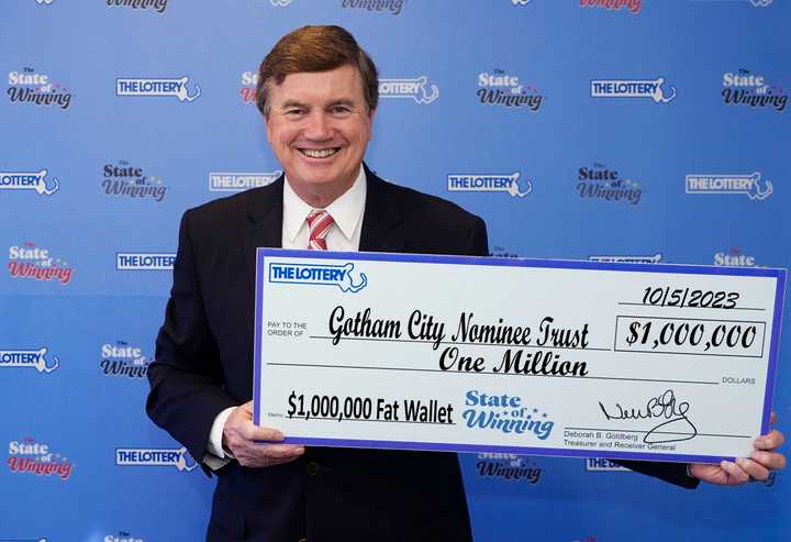 David Spillane, a representative of Gotham City Nominee Trust, collects a $1 million check for a lottery winner who wishes to remain anonymous.