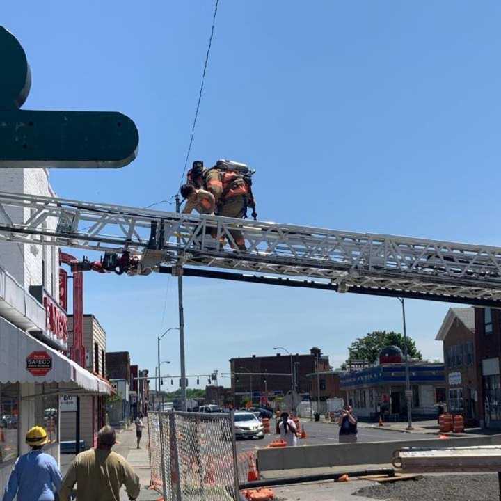 Kingston Firefighters use a ladder truck to rescue three children from a rooftop during a fire.