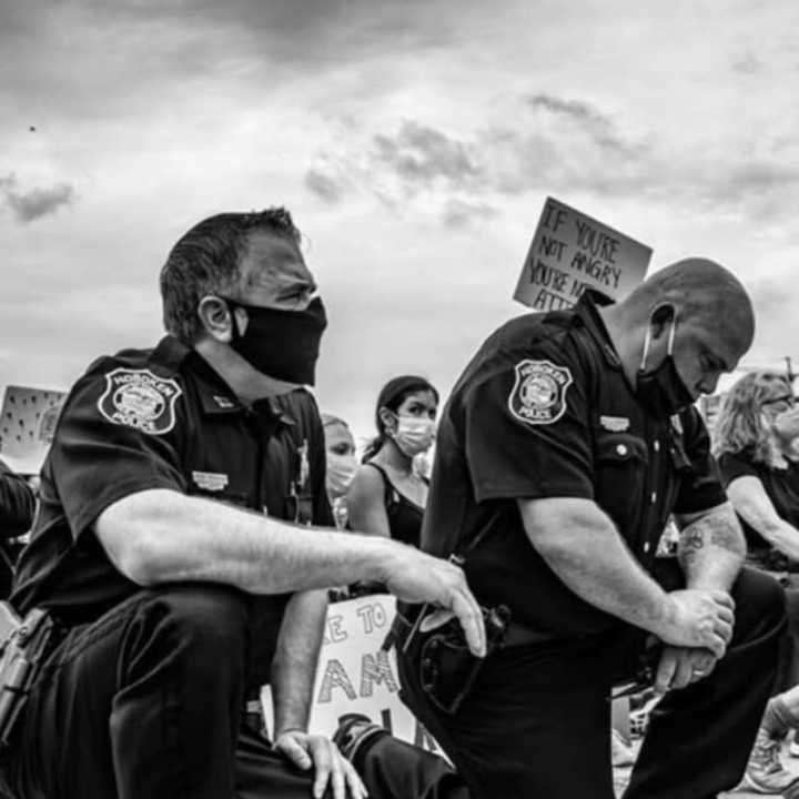 Police officers kneel in solidarity during a Hoboken protest in early July.