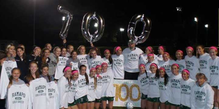 The Ramapo High School girls soccer team celebrate a milestone win with head coach Paul Heenehan. 