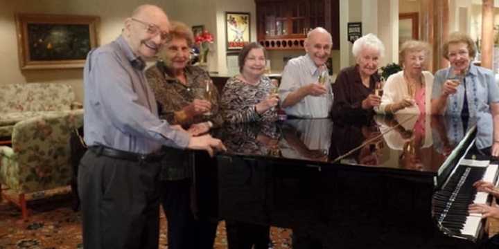 Esplanade at Palisades residents gather around the piano.