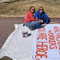 <p>&quot;Just thought this needed to be said.&quot; Pat Plumadore Arimborgo (left), Karen Lippin work on their sign.</p>