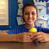 <p>Clifton staff member, Marissa Rossi, with her favorite cupcake, the Lemon Drop: yellow cake filled with lemon pie filling and topped with cream cheese icing.</p>