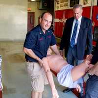 <p>Chief Tom Loreto, left, and a Mahwah fireman lift the new, 165-pound life-like dummy the department purchased with the new grant.</p>