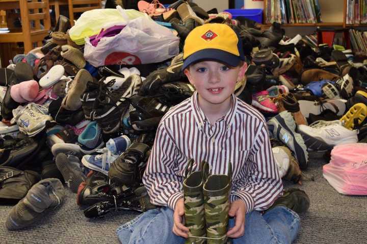 Washignton Township scout, Derek Kaine, 2nd grade, with the 1,000 pairs of shoes collected for Soles4Souls.