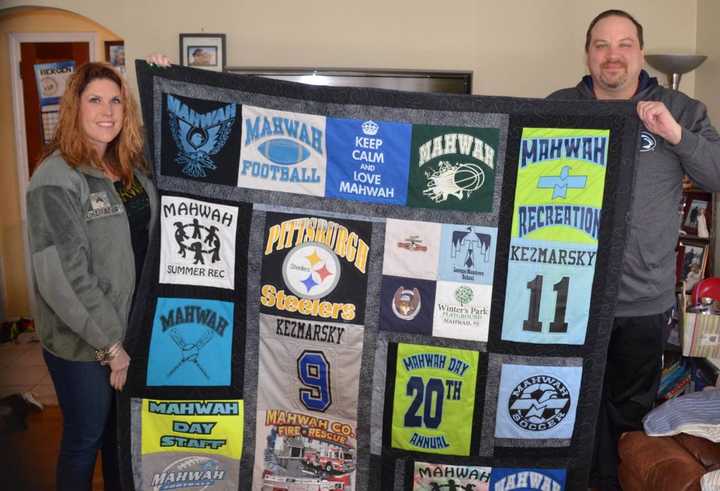 Tammy Marcus, at left, and Ben Kezmarsky hold up a Mahwah-themed quilt.