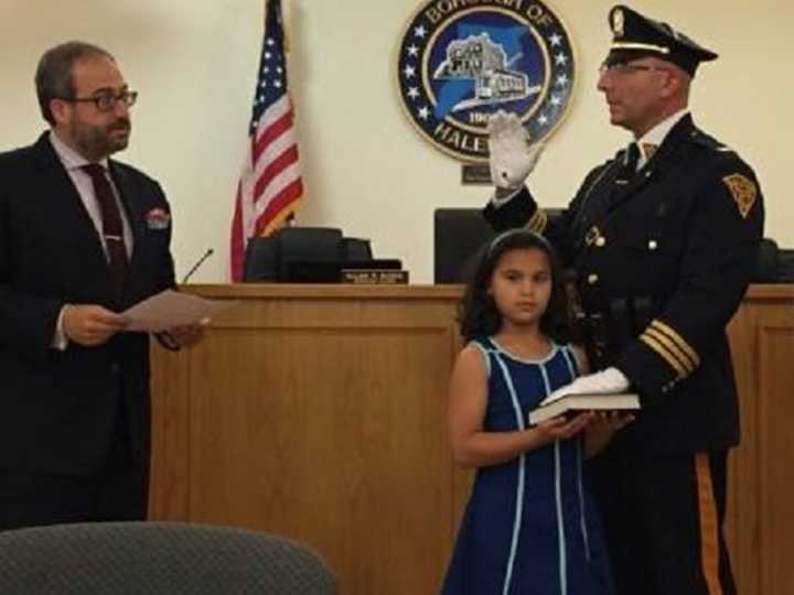 New Haledon Deputy Police Chief Angelo Daniele, with his niece holding the Bible, is sworn in by Mayor Domenick Stampone.