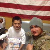 <p>Fernando Moreno-Rivas, who was killed in a wrong-way crash on Route 8 in Shelton, presents gifts to an Afghanistan boy in 2012. Fernando Moreno-Rivas was an Army medic.</p>