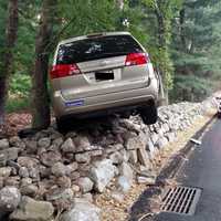 <p>The vehicle came to rest on a rock wall.</p>