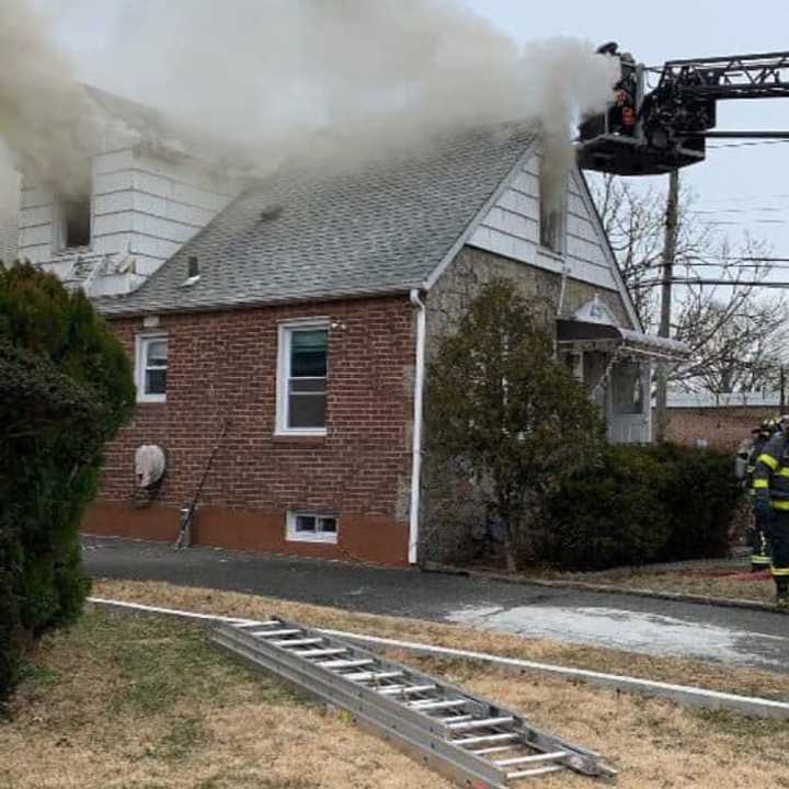 Three people were rescued by a police officer from a burning home in New Hyde Park.