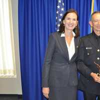 <p>U.S. Attorney Deirdre Daly with Officer Cesar Ramirez after Ramirez was recognized for organizing an Aug. 3 vigil outside the Norwalk Police Department headquarters.</p>