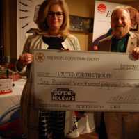 <p>Jim Rathschmidt accepts a check from Putnam County Executive MaryEllen Odell at a recent fund-raising for United for the Troops.</p>