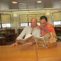 <p>Marc and Carl read in the library.</p>