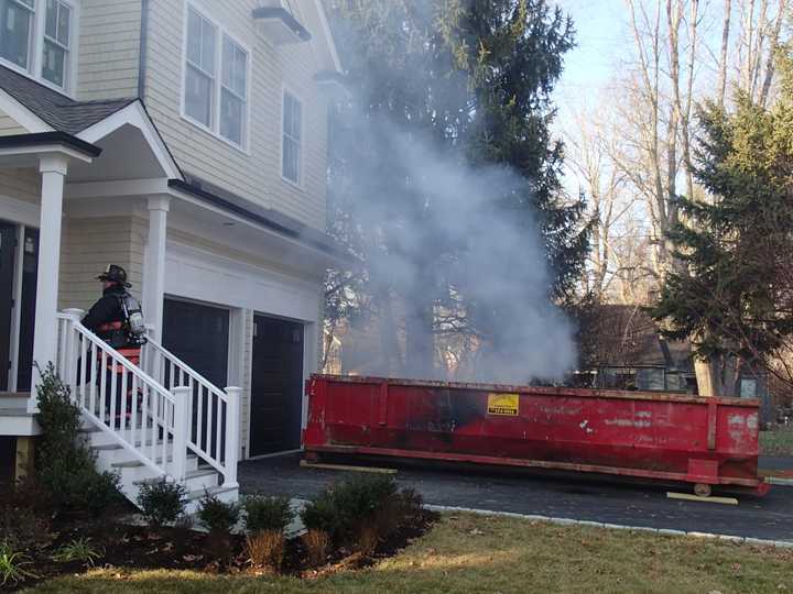 A burning dumpster is very close to a  residence on Westfair Drive in Westport on Wednesday afternoon.