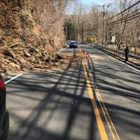 <p>Redding police officers direct traffic around a rockslide on Route 107 on Tuesday morning.</p>