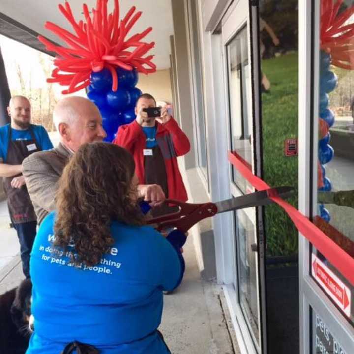 Westport First Selectman Jim Marpe — with his dog, Olivia — uses the giant scissors for the grand opening of a new Petco on the Post Road East.