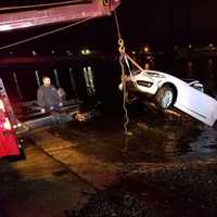 <p>The car is pulled from the Saugatuck River early Sunday in Westport. An elderly man died after the car went into the chilly waters Saturday evening, but first responders saved a woman.</p>