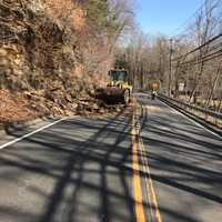 <p>A crew from the Redding Highway Department clears debris after a rockslide on Route 107 on Tuesday morning.</p>