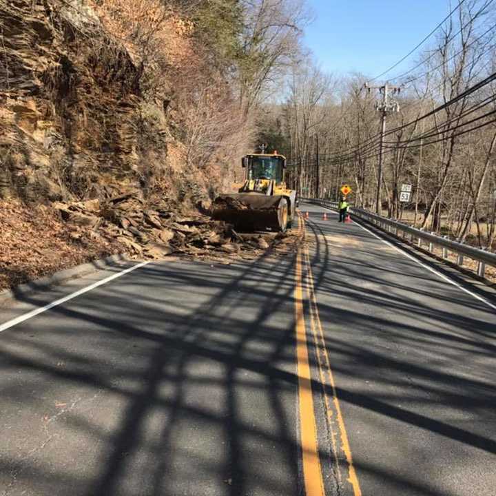 A crew from the Redding Highway Department clears debris after a rockslide on Route 107 on Tuesday morning.