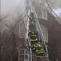 <p>Norwalk firefighters battle a smoky blaze Saturday at 30 West Rocks Road. One man died in the fire.</p>