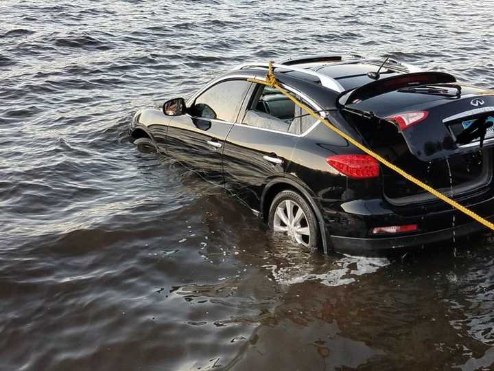 Stevenson volunteer firefighters and a tow company pull a car out of Lake Zoar in Monroe on Wednesday.