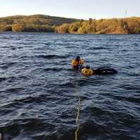 <p>Firefighters from Stevenson Volunteer Fire Company affix cables to a car that ended up in Lake Zoar in Monroe.</p>