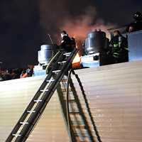 <p>Firefighters braved flames blowing through the roof.</p>