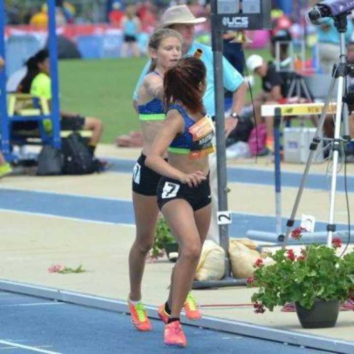 Sunny Nagpaul accepting a baton during a race at the New Balance Indoor National Track and Field Championships.