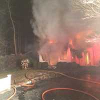 <p>Firefighters respond to the fire at a home on Shadow Lane in Wilton Thursday night.</p>