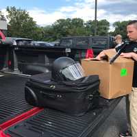 <p>An officer prepares to return his equipment in Hackensack.</p>