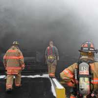 <p>Mahopac firefighters keep an eye on the entry crews working the fire.</p>