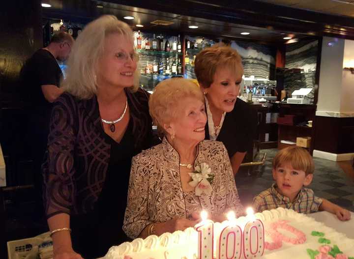 Marge Santangelo LaBrusciano of Rye Neck celebrated her 100th birthday on Sunday. She posed before blowing out candles with daughters Eileen DeFazio of North Carolina and CarolAnn DellaCrosse of White Plains as great-grandson Ben Bouchard looks on.