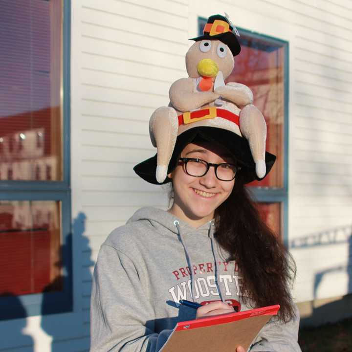 A student from the Wooster School in Danbury gets into the season as she and her classmates deliver the 129 turkeys donated for Thanksgiving meals. 