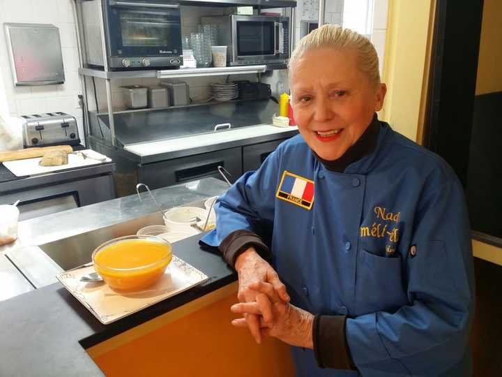 Méli-Mélo Catering Manager, Chef Nadia Ramsey poses next to a bowl of soup.