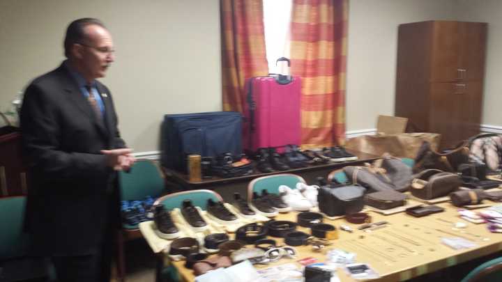 Harrison Police Chief Anthony Marraccini shows stolen goods and fake ID recovered this week after arresting three suspects in a car break-in Sunday in Purchase. In addition to cash and cellphones, police recovered luxury handbags, belts and shoes.