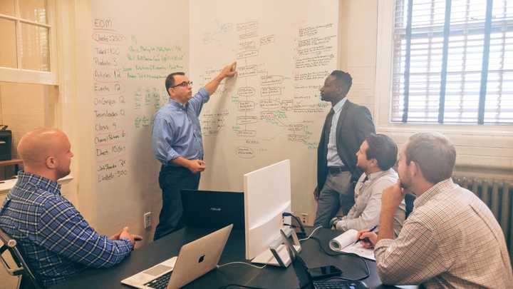 The HelpGrowUSA team works on business solutions at its Clarence Street headquarters in Bridgeport.