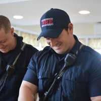 <p>Ridgewood firefighters peel carrots at HealthBarn USA.</p>