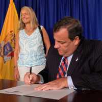 <p>Chris Christie signs a pardon for Orange County resident Gail Naples.</p>