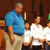 <p>Richard and Jung Courville, with their children, receive a blessing at St. Jerome in Norwalk at a past event.</p>