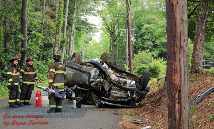 Two people had to be extricated from a vehicle after it hit a tree and rolled over, trapping them inside.