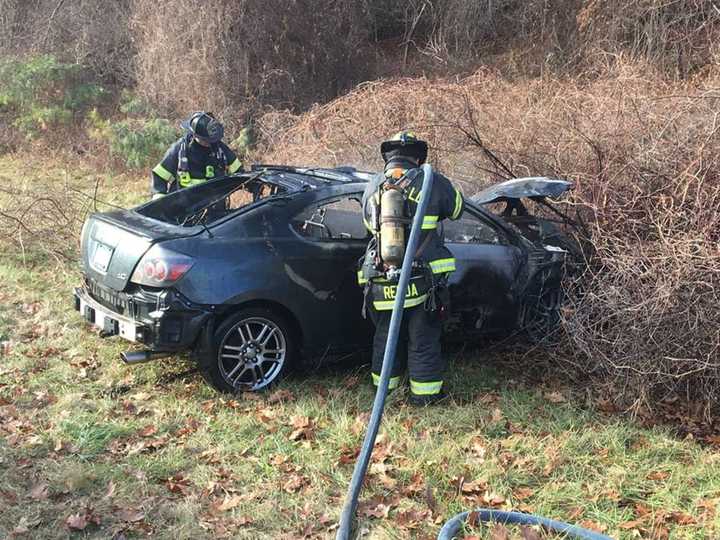 Fairfield firefighters quickly douse a burning car on I-95 on Wednesday afternoon.