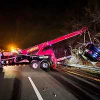 <p>Bergen Brookside Auto Body &amp; Towing lifted the smashed vehicle out of the ravine and onto a flatbed.</p>