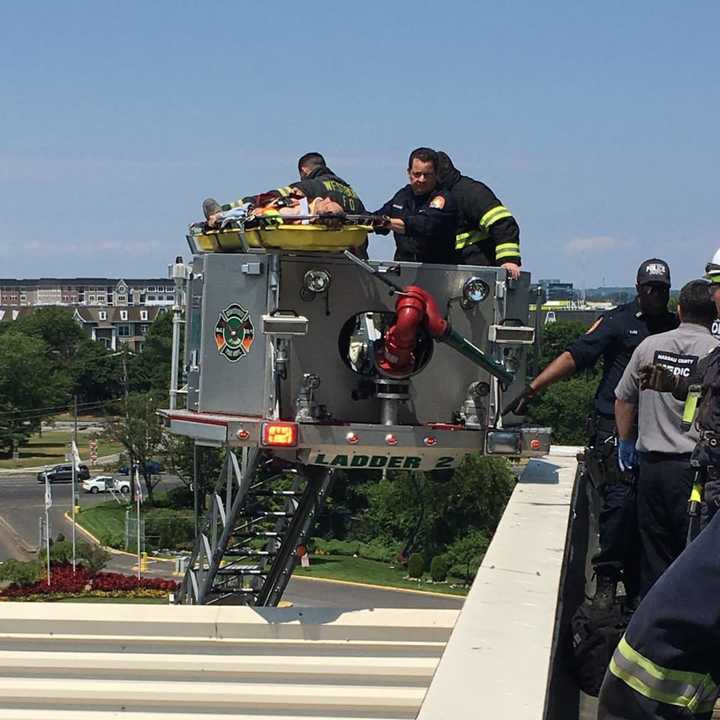 A worker at a Nassau County building needed to be rescued after falling through a hatch on the roof in East Garden City.