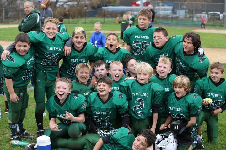 The third- and fourth-grade White team players are all smiles after completing an undefeated season.